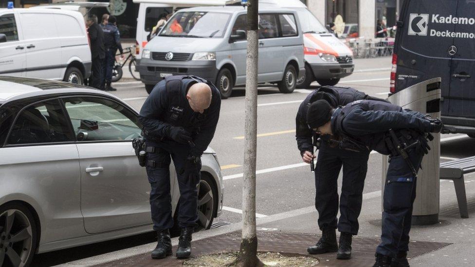 Police teams check the area following the shooting incident in Zurich