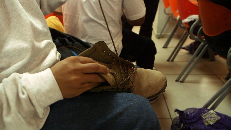 A man threads laces in to his shoes