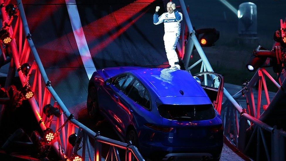 Driver standing on Jaguar F-Pace car