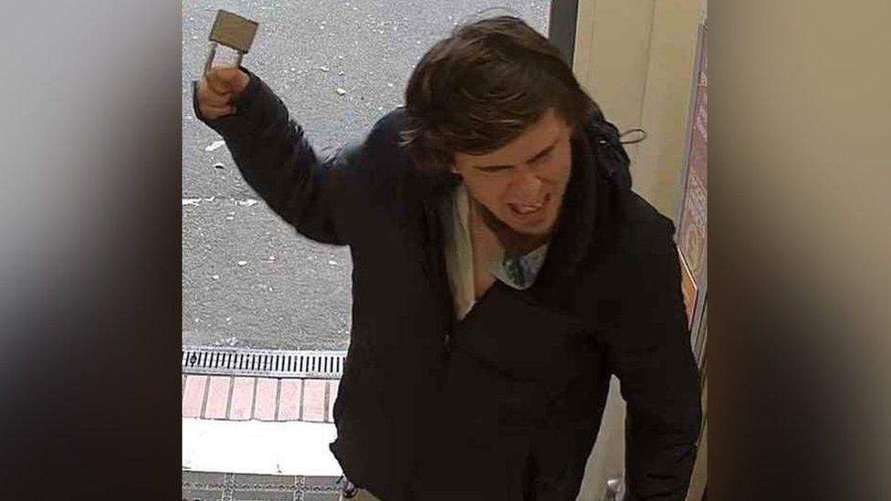 An image of Sam Sharpe brandishing a padlock during an incident at a Sainsbury's store in Lenton