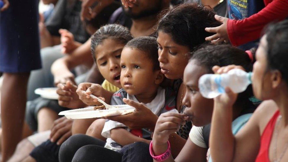 Venezuelan migrants eat after arriving on Los Iros Beach after their return to the island, in Erin, Trinidad and Tobago, November 24, 2020.