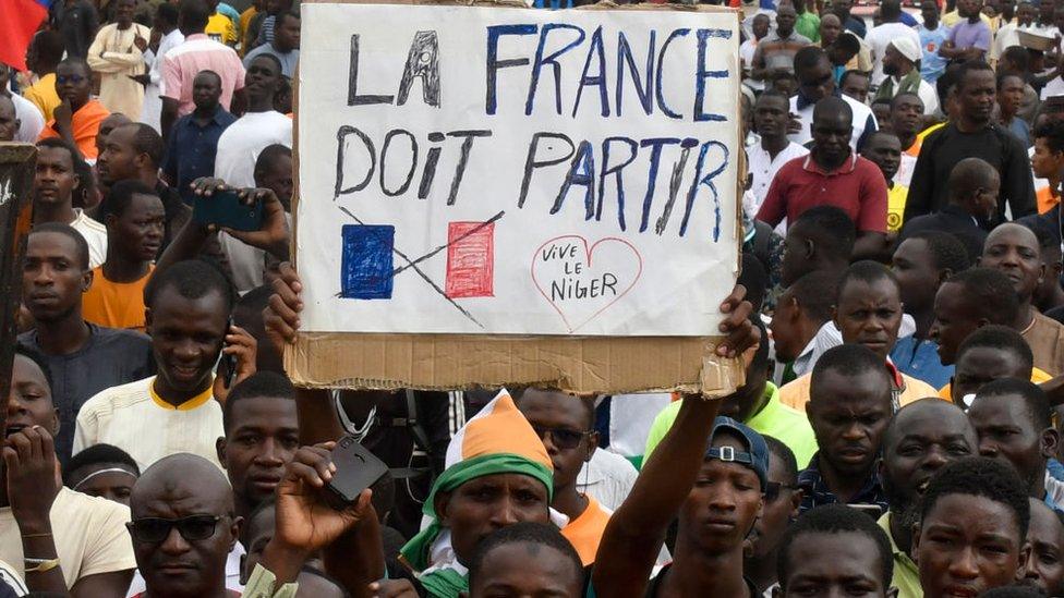 Protestors holding a banner against France during demonstrations in support of the coup in Niamey