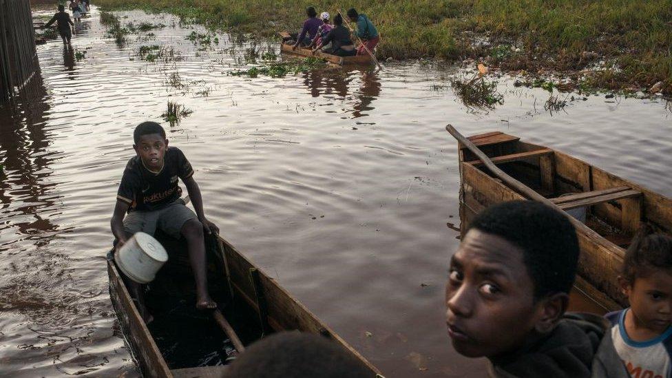 People in Madagascar on a boat after flooding