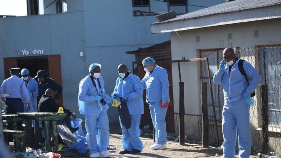 Forensic personnel investigate after the deaths of patrons found inside the Enyobeni Tavern