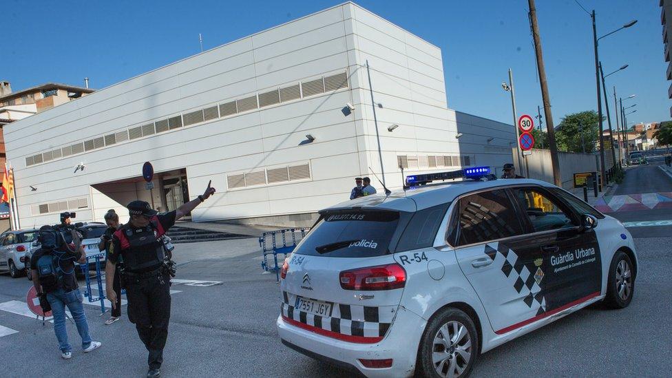 A Catalan police officer gestures outside the police headquarters at Cornellà de Llobregat on 20 August