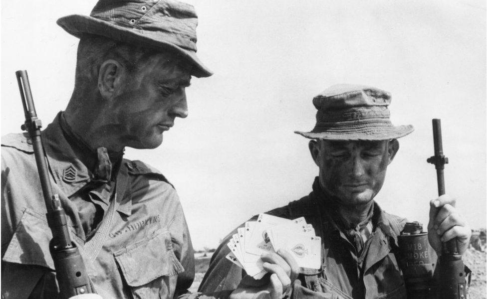 16th January 1967: Two US Marine sergeants getting a supply of Ace of Spades cards, known as the 'death cards' which the reconnaissance forces leave as a warning to the Viet Cong, before going on patrol in enemy territory. (Photo by Keystone/Getty Images)