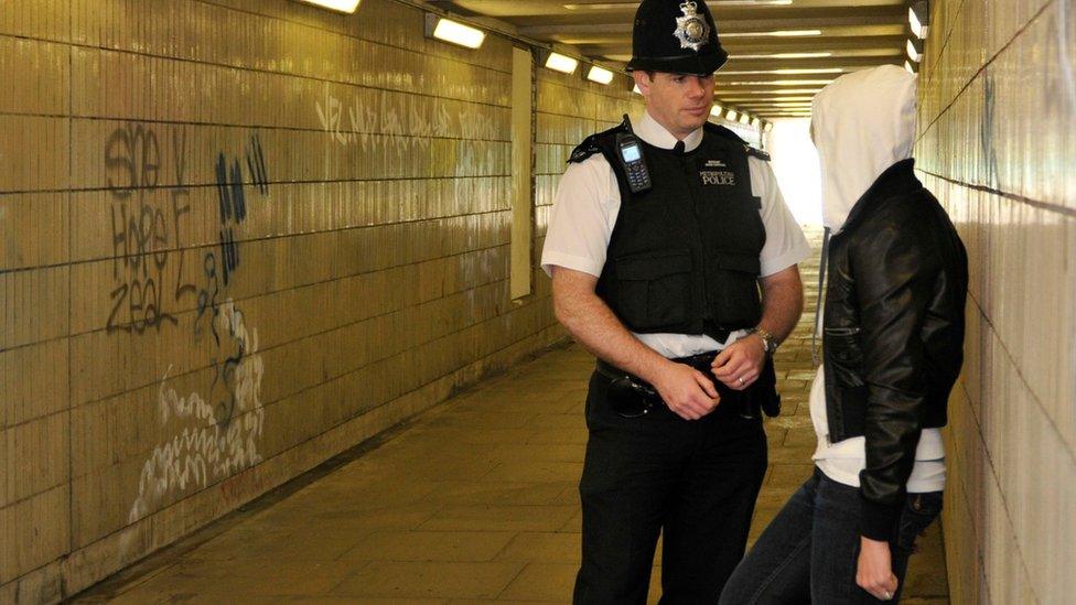 A police officer talking to a youth