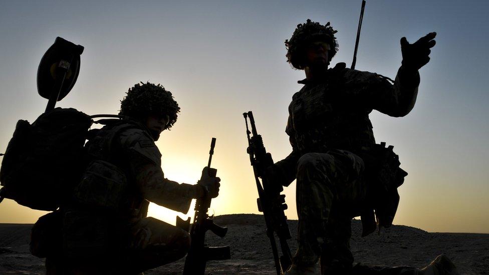 British soldiers pictured in silhouette during a dawn patrol in the Nahr-e Saraj district of Helmand Province, Afghanistan