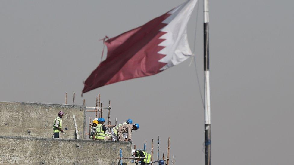 Construction workers are pictured on a building site on May 9, 2014 in Doha, Qatar