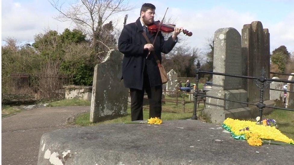 Violinist plays at St Patrick's grave in Downpatrick, County Down