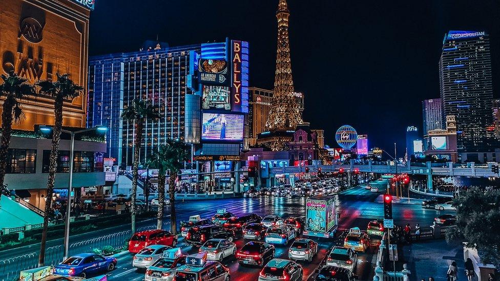 The Las Vegas strip at night with cars lined up on the road