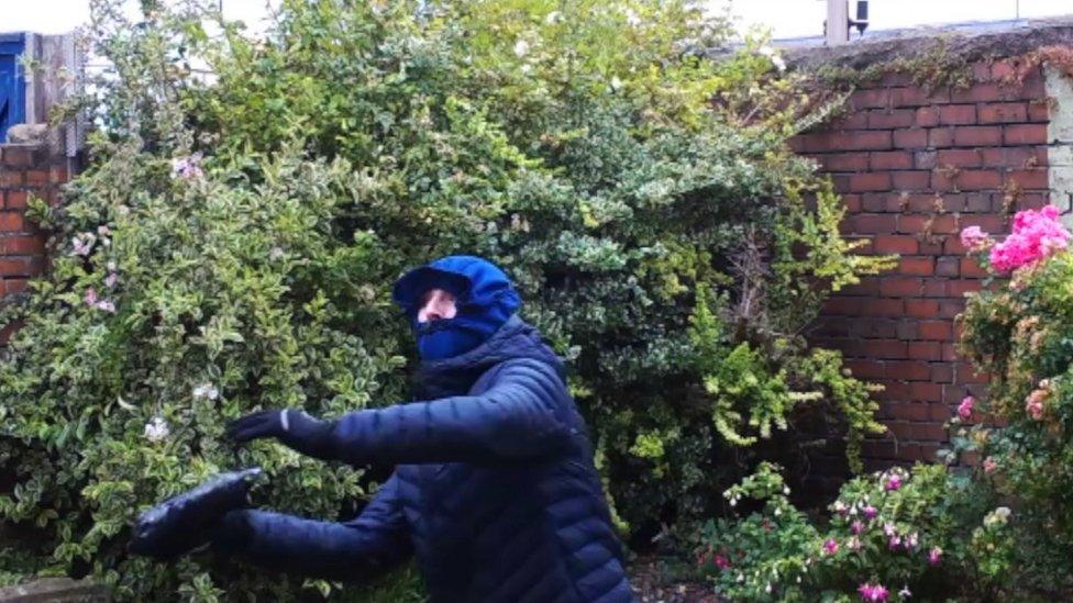 Man throwing package over prison wall