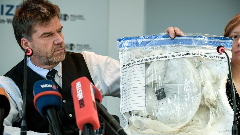 Police with sky lantern like those found at scene of fire, 2 Jan 20