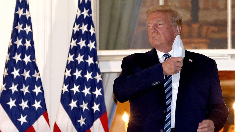 U.S. President Donald Trump removes his mask upon return to the White House from Walter Reed National Military Medical Center on October 05, 2020 in Washington, DC