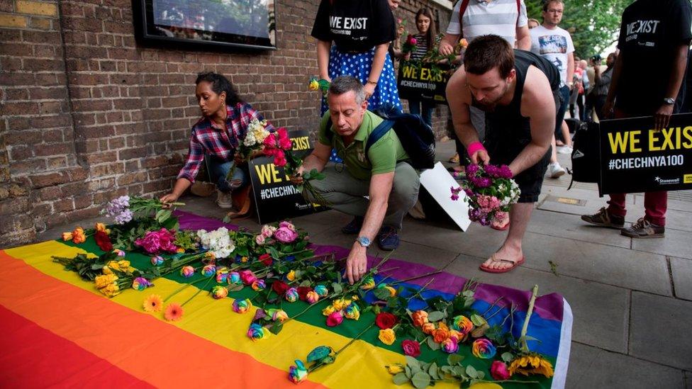 People leave flowers at demonstration at Russian embassy in London