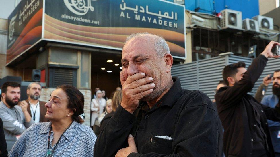 Colleagues of the two Al Mayadeen journalists, who Lebanese officials say were killed by an Israeli strike in southern Lebanon, mourn outside the channel's office in Beirut, Lebanon (21 November 2023)