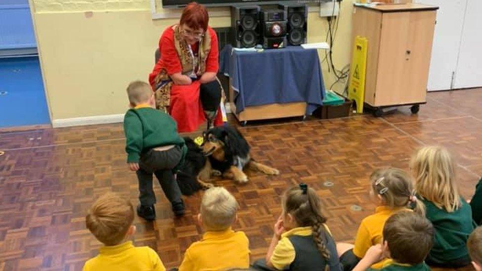 Carolyn Coster with Duke in a school