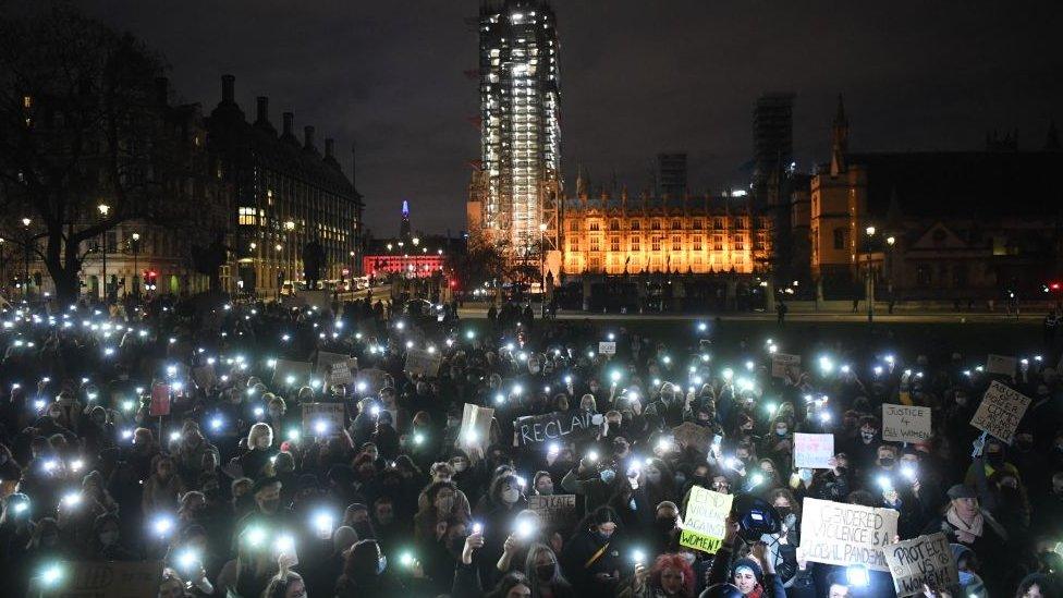 Large group of people holding torches and protest signs in London