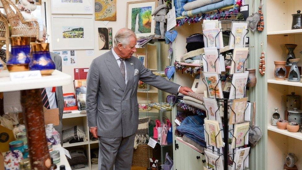 Prince Charles look around a gift shop before unveiling a stained glass window at Myddfai Community Hall near Llandovery, Carmarthenshire