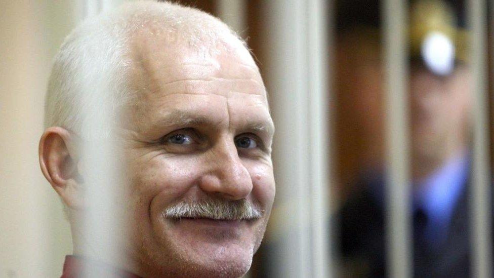 Belarusian human rights activist Ales Bialiatsky smiles as he waits in a trial cage inside a courtroom prior to a court session in Minsk, Belarus, 24 November 2011