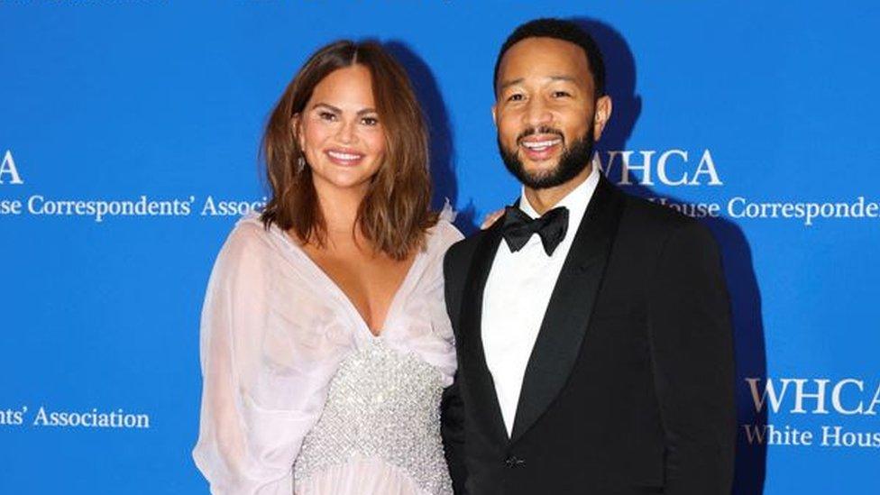 A glamourous couple, John Legend and his wife Chrissy Teigen, posing on the red carpet