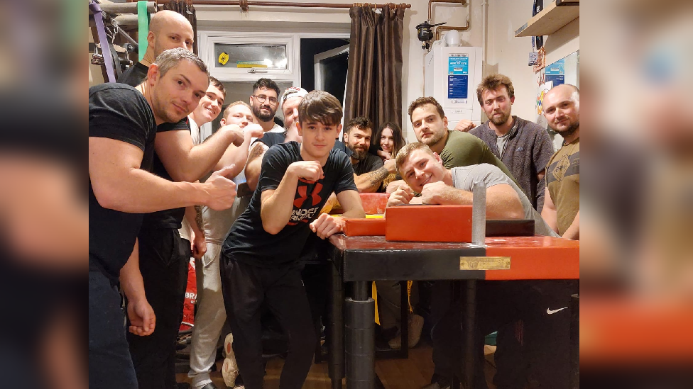 Greg with men training for arm-wrestling