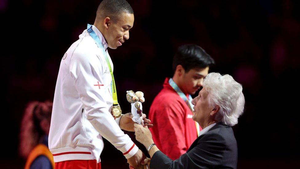 Dame Louise Martin awards Joe Fraser of Team England a Gold Medal at the 2022 Birmingham games