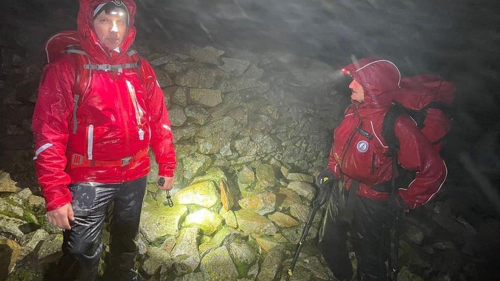 Two volunteers in heavy rain