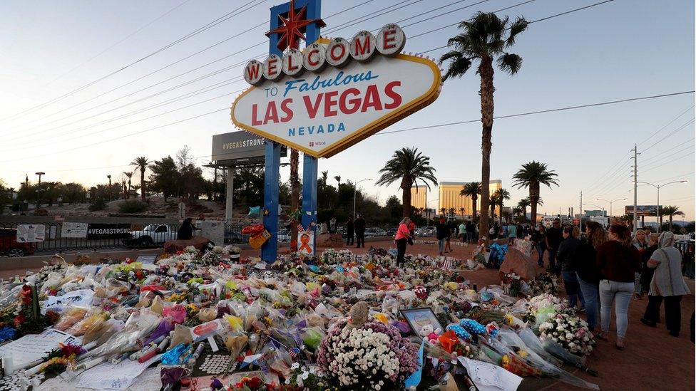 The "Welcome to Las Vegas" sign is surrounded by flowers and items, left after the October 1 mass shooting, in Las Vegas, Nevada U.S. October 9, 2017.