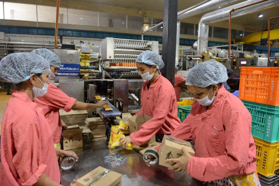 Indian workers pack ice cream cones at a production facility at Vadilal Industries Ltd. at Pundhara village, around 60 kms from Ahmedabad on May 28, 2013