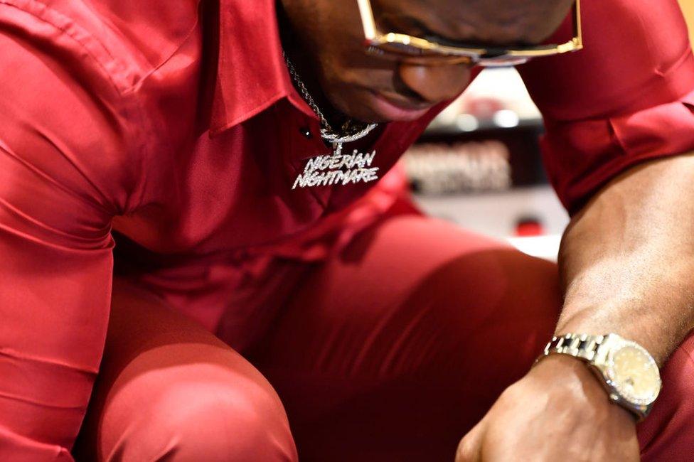 Kamaru Usman of Nigeria wears sunglasses and necklace reading "Nigerian Nightmare".