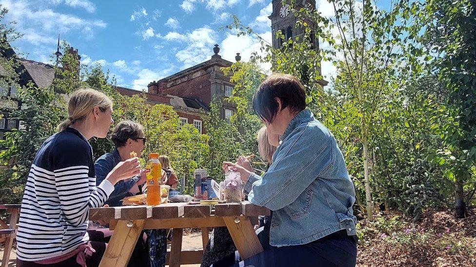 People sat on a picnic bench in the urban forest