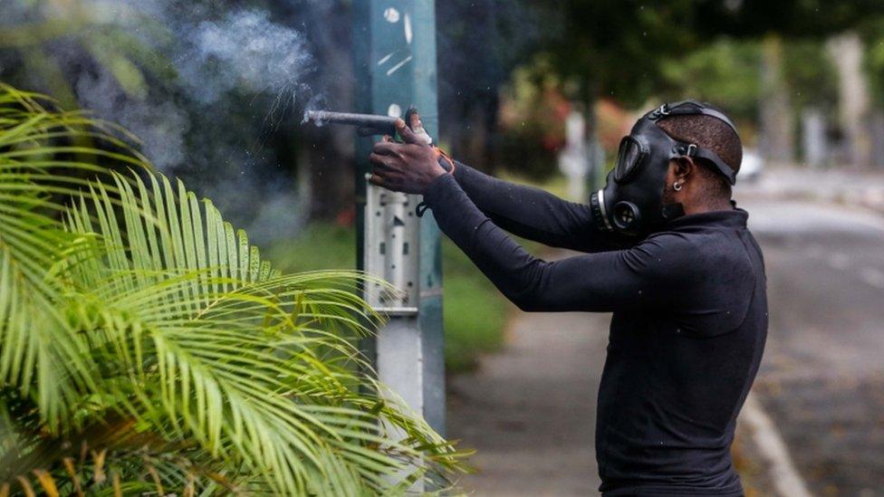 A protestor confronts members of the National Bolivarian Guard during a demonstration against the vote for a Constituent Assembly in Caracas, Venezuela, 30 July 2017