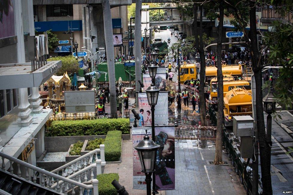 Workers cleaning up and repairing the Erawan site after the bomb