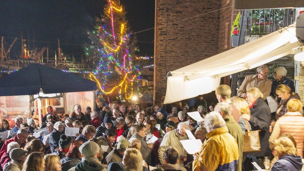 Carol singers by Christmas tree