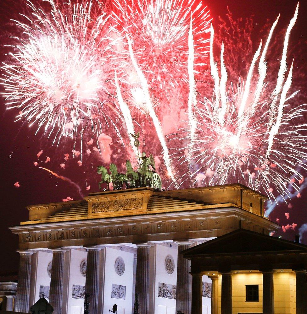 Fireworks explode next to the Quadriga sculpture atop the Brandenburg gate during New Year celebrations in Berlin