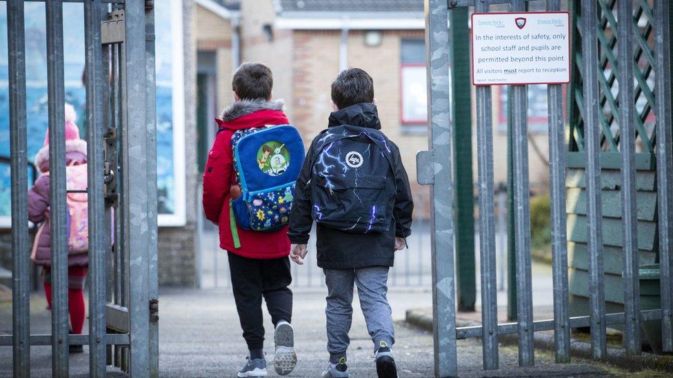 kids walk through school gates.