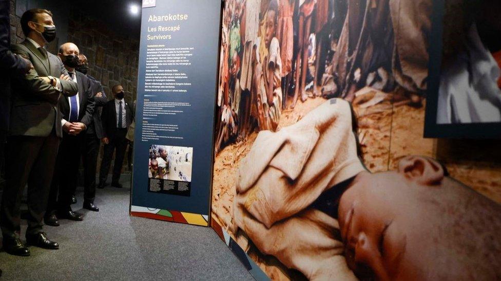 French President Emmanuel Macron (L) and French European and Foreign Affairs Minister Jean-Yves Le Drian stop to look at images during their visit to the Kigali Genocide Memorial, where some 250,000 victims of the massacres are buried, in Kigali on May 27, 2021.