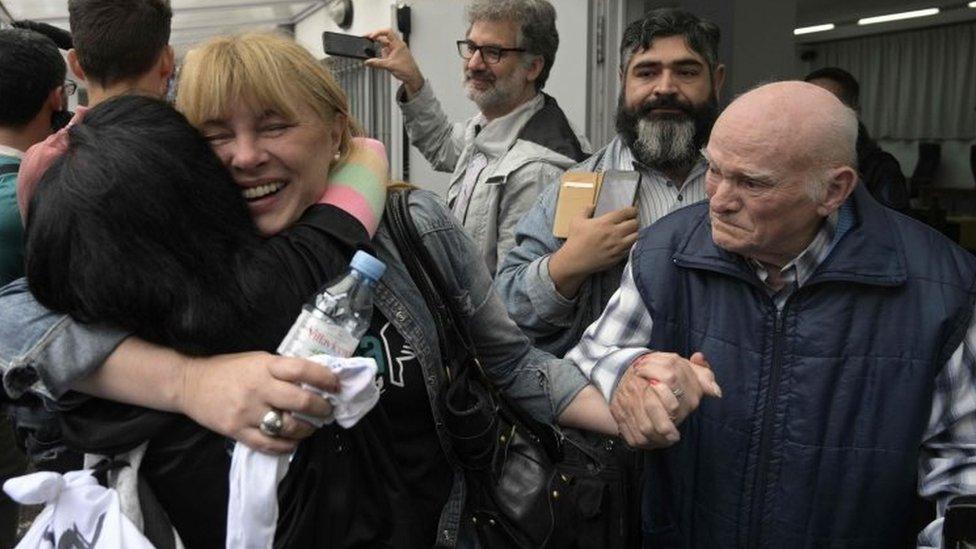 Carlos Gareis (right), a former Ford worker and a political prisoner, holds the hand of his daughter Estela (centre) after the court's verdict in Buenos Aires, Argentina. Photo: 11 December 2018