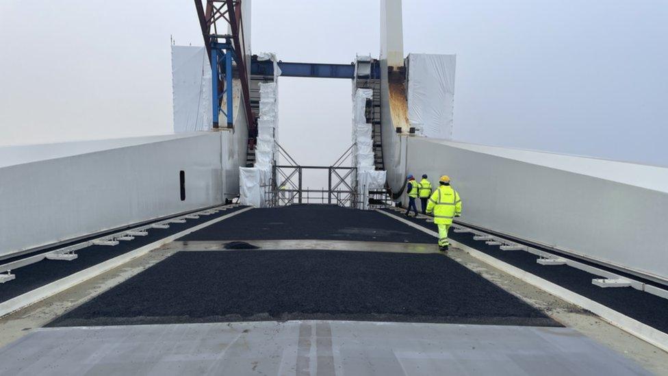 Large section of bridge with workers walking along it