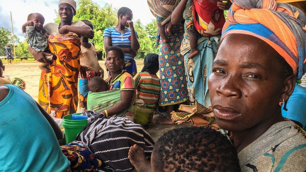 Women carrying their children with their scarce belongings after the passage of the cyclone Idai in Matarara