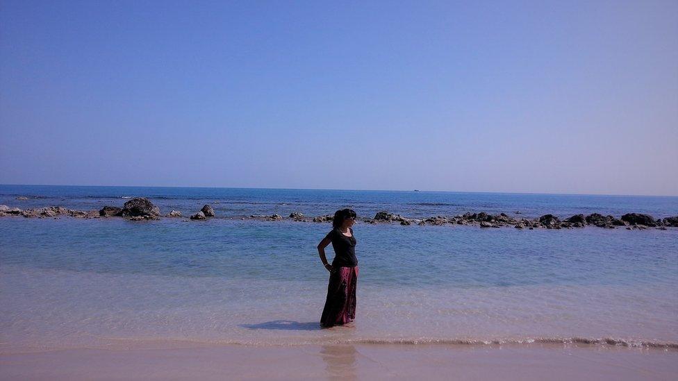 Woman in Sri Lanka on beach next to sea