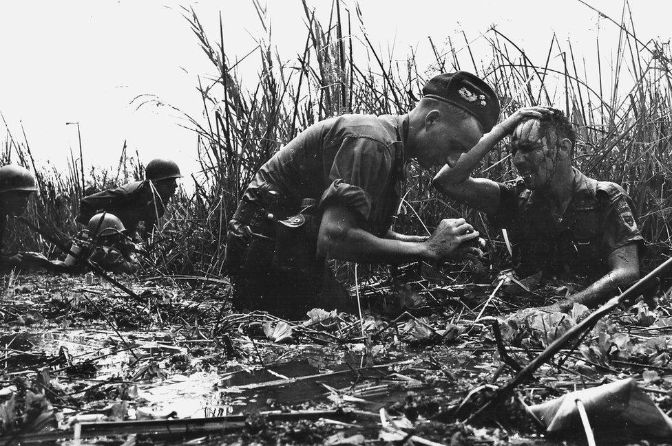 An Australian medic tends to a wounded soldier 10 miles south of Soc Trang in the Mekong Delta, February 1970