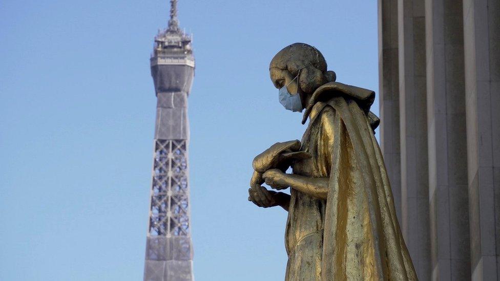 Masked statue with Eiffel Tower in background