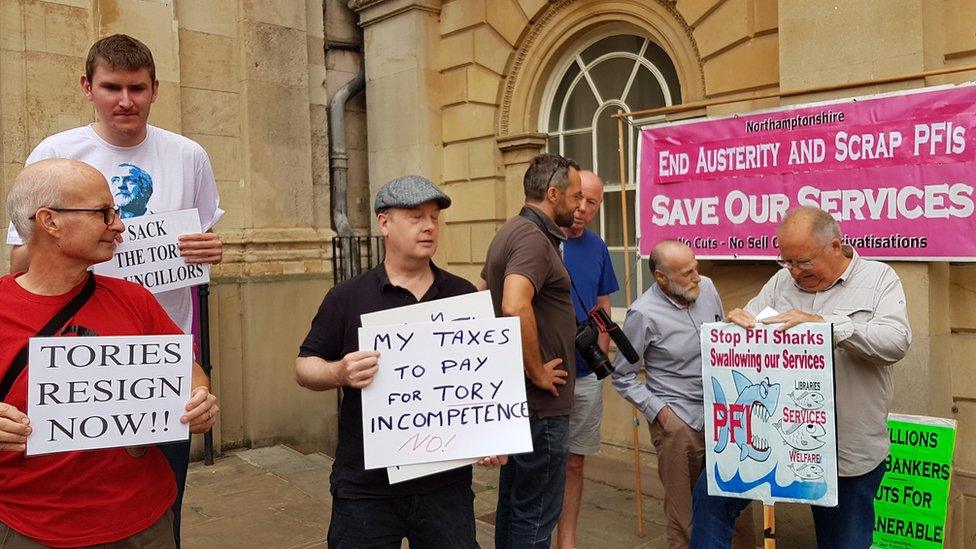 About 20 people gathered outside County Hall to protest against cuts.