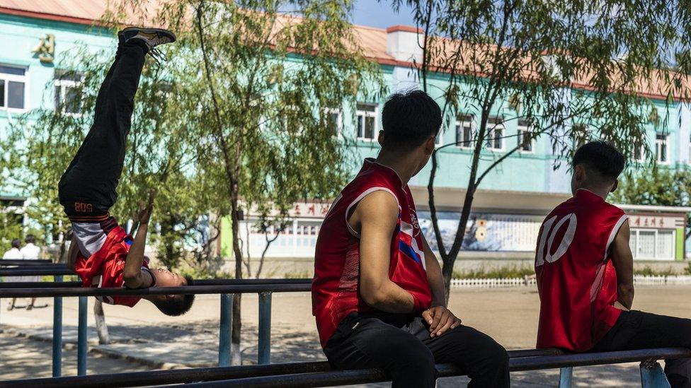 Boys practice on the gymnastic parallel bars in their school playground in Hoeryong