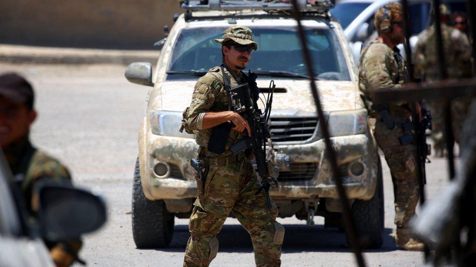 A member of the US forces stands guard in Syria