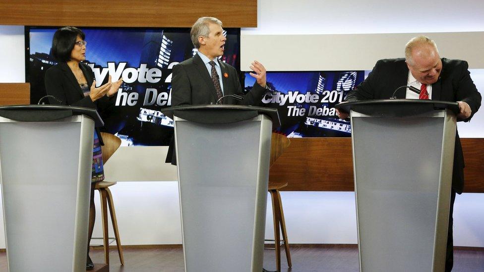 Then Toronto Mayor Rob Ford (R) laughs as he takes part in a Toronto Mayoral election debate with candidates Olivia Chow (L) and David Soknacki in Toronto, in this March 26, 2014