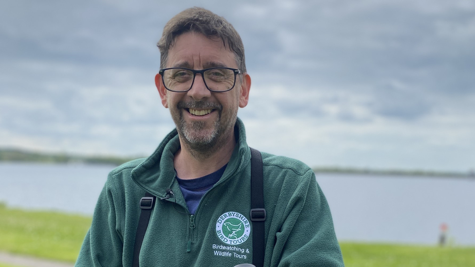 A man is pictured in front of a reservoir.