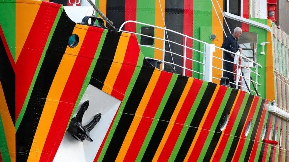 A man stands on the deck of the brightly painted former pilot ship The Edmund Gardner at the Albert Dock in Liverpool, northern England, June 11, 2014.